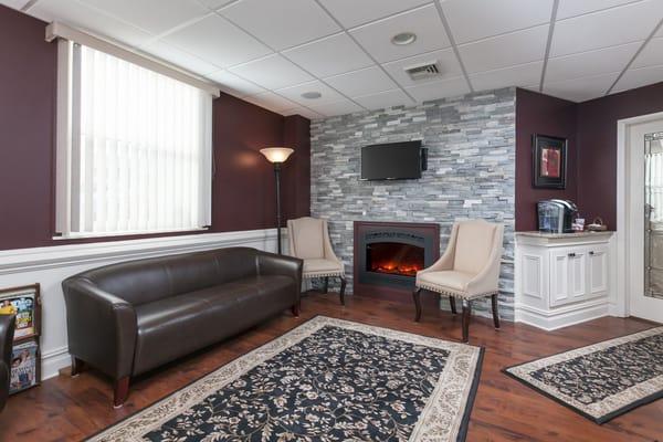 Comfortable waiting room with flat screen tv and coffee station.