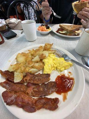 Breakfast bacon and eggs with home fries.