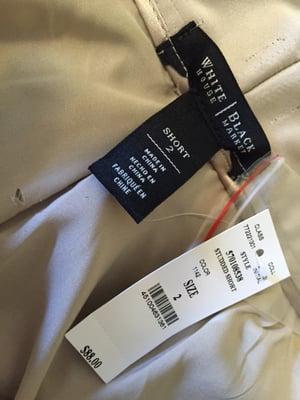 Tear in the lining and crude placement of the label after waistband alteration.