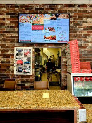 June 2021: The wall menu above the ordering/pickup counter. That's Owner Sam in the background