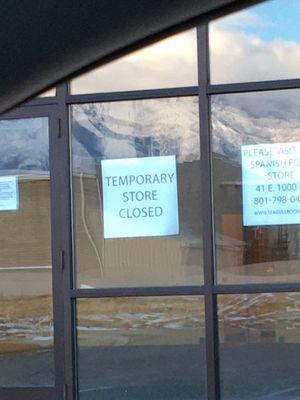 Sign announcing store closed and directing customers to other location