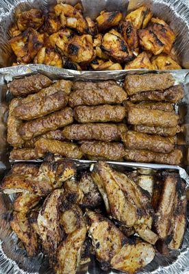 Mixed grill platter with chicken thigh, beef luleh kebab, and pork chops