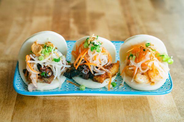 A trio of our meat and seafood bao buns with pickled carrots and radish.