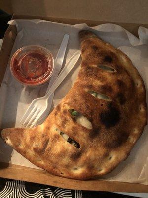 This is the huge veggie calzone with its side of red sauce.