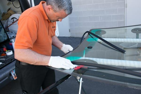 Preparing the new windshield and installing the new molding.