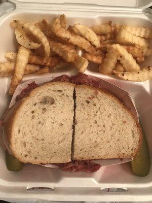 Corned beef sandwich with fries .