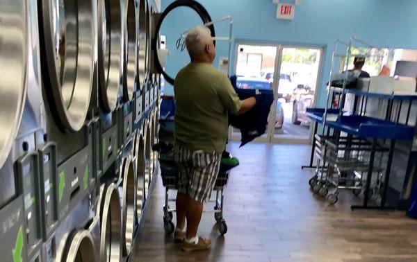 Laundry Heaven customer folding  clothes after the dryer