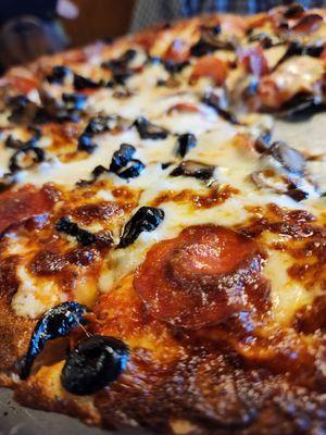 Pepperoni pizza with black olives, mushrooms and extra cheese