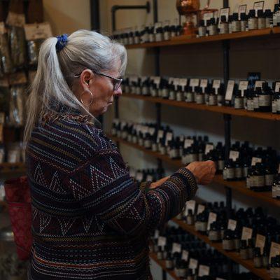 Woman looking at essential oil bottles.