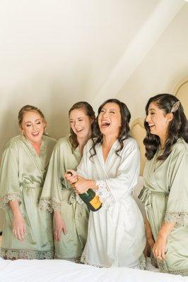 Bride and Bridesmaids pop champagne to celebrate