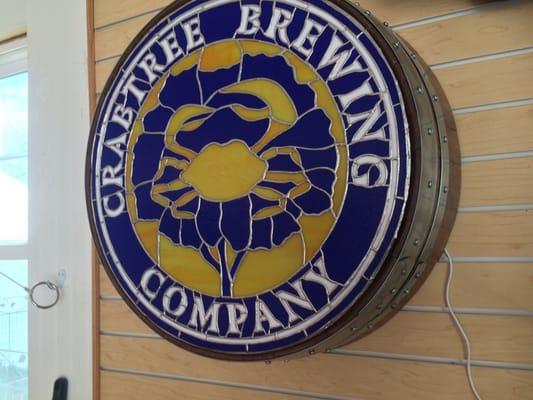 Crabtree Brewing backlit stain glass sign on a barrel made by Bonnie French.