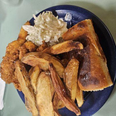 Chicken strips, potato wedges, coleslaw, and homemade bread.