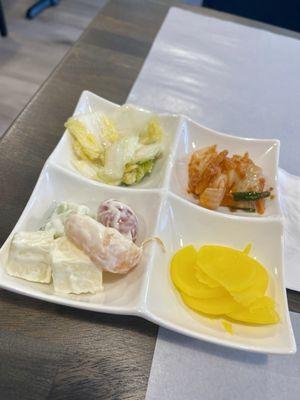 Sides: spicy kimchi, regular kimchi, fruit salad and yellow radish