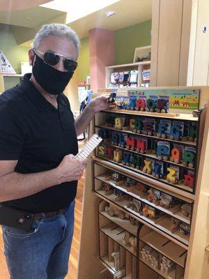 Who is this masked man picking out a wooden train spelling our grandson's name?