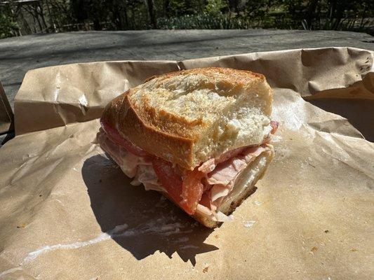 Half of the the impossibly thin-sliced mortadella, ricotta, tomato, oregano sandwich