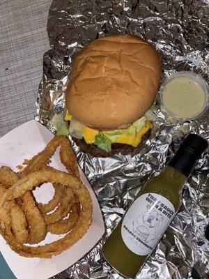 Bacon cheeseburger with onion rings and their hot sauce