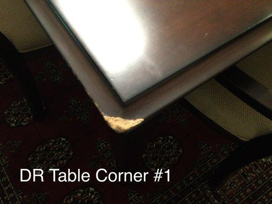 All four corners of the dining room table look like this. Looks like water damage causing swelling as well.