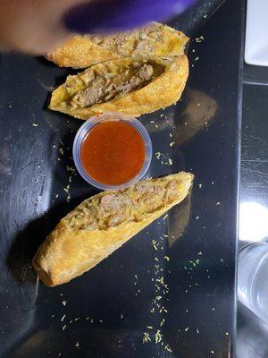 Ribeye Steak and cheese Egg Rolls with a delicious sauce