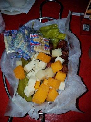 Sausage cheese pickle and pepperoncini basket with crackers.