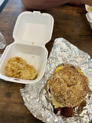 Bacon, egg, and cheese on everything bagel with a side of cheesy hash brown casserole