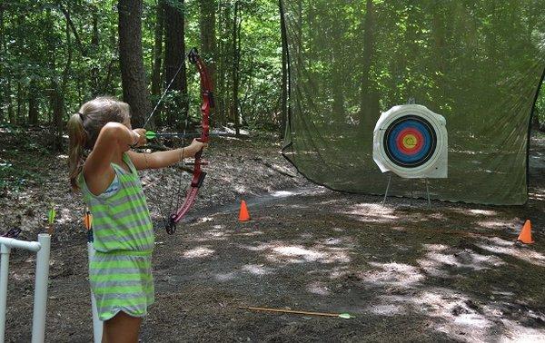 Girl Scout practicing archery at summer camp