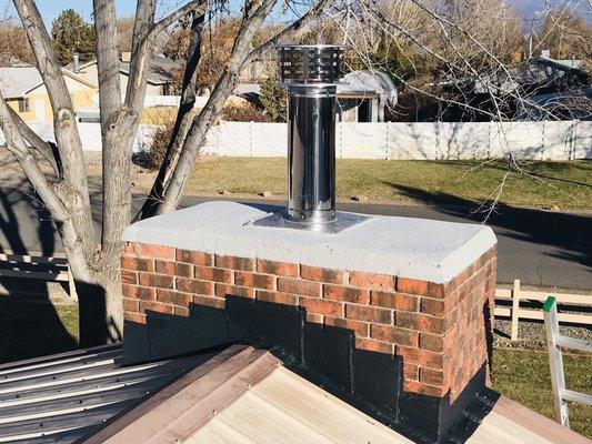 Crown and flashing repaired and insulated chimney liner extended up to meet minimum height requirements above the roofline.