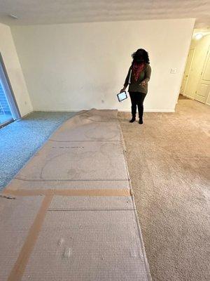 Pulled back carpet at the sliding glass door with water spots being claimed at 'pet urine'