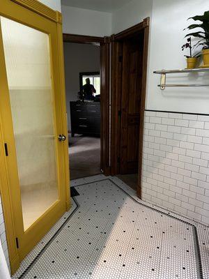 Subway tiled wainscoting, detailed bordered penny tile floor, painted closet door