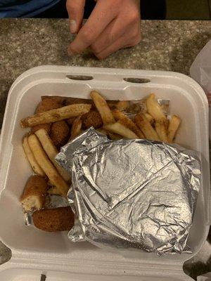 Burger and fries with half eaten hush puppies