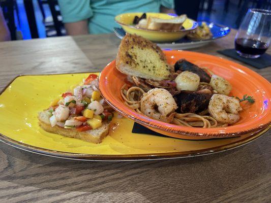 Scallops, shrimp and mussels pasta with mango shrimp crostini.