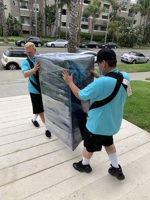 Two of our lead professional movers using the shoulder dolly to move this 150lb oak wood dresser.