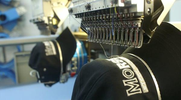 Hats being embroidered by our six-head industrial machine