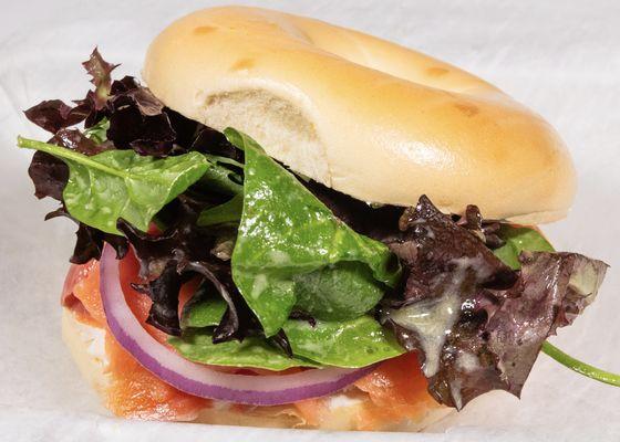 Smoked Salmon Bagel with sliced red onion, capers, dijon vinaigrette greens and cream cheese