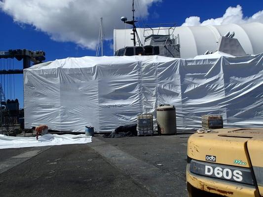 A Navy Torpedo Weapon Retriever under shrink wrap containment at the Keehi Marine Center