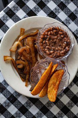 Beef Liver and Onions served with potato wedges and black eyed peas