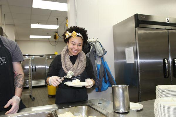 A volunteer plates food at Blanchet House.