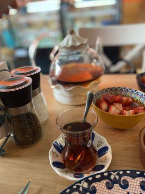 Tea over a candle to stay warm and strawberries, part of Turkish breakfast for two