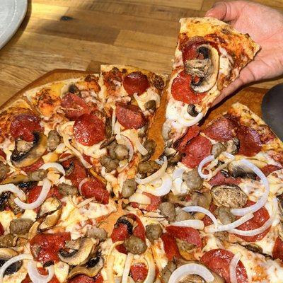 Rosa's 5 million dollar pizza is topped with pepperoni, sausage, onions, and mushrooms