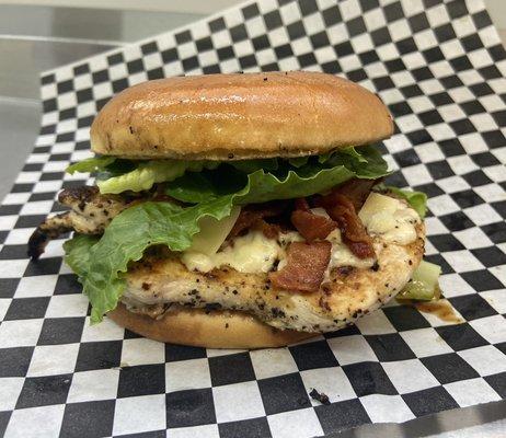 El Cesár: a grilled chicken sandwich with Caesar dressing, bacon, romaine lettuce, and parmesan cheese.