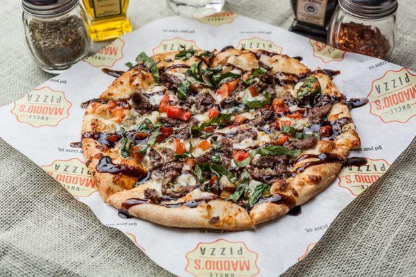 STEAK & BLUE PIZZA: Garlic olive oil, spinach, mozzarella and blue cheese, diced tomatoes, grilled steak, balsamic glaze & fresh basil.