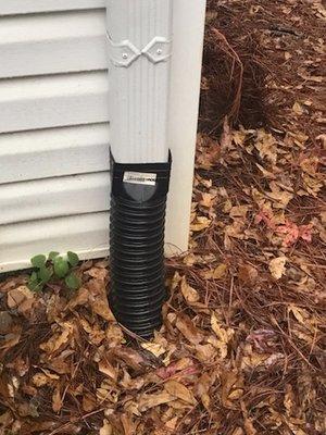 This is how Complete Concrete buries gutter downspouts -- with ugly corrugated plastic that eventually collapses.