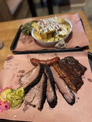 Brisket with thick bark, sausage, ribs and brisket nachos.