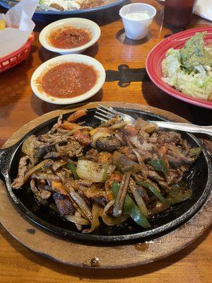 Steak fajitas with rice, beans and tortillas.