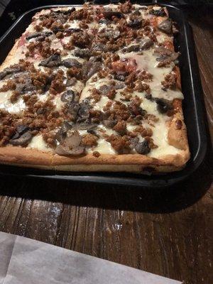 Full tray of red pizza with sausage and mushroom. Average for the town, if not below.