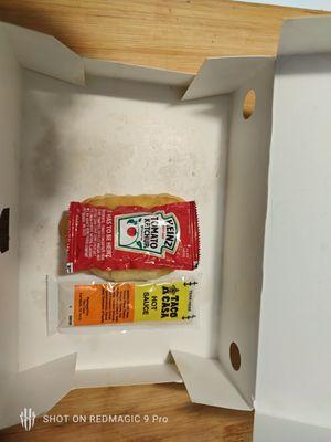 their ketchup packet on top of their biscuit with a taco casa packet next to it for size reference