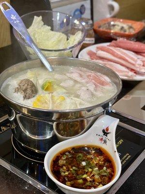 Bone Broth with cabbage, corn, pumpkin, and pork slices with chili oil and sour and sweet garlic soy sauce on the side