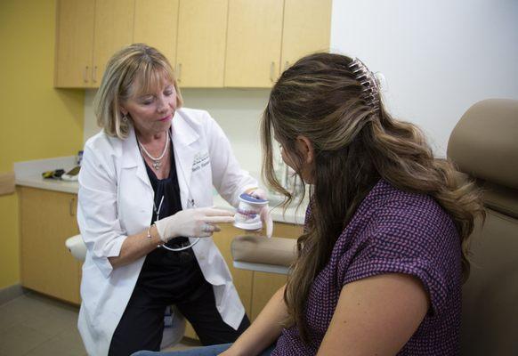 Dr. Beth Hamann providing a demonstration with a model to a patient.