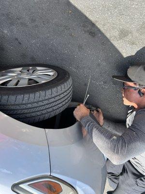 One of the tow truck drivers taking off the plastic piece.