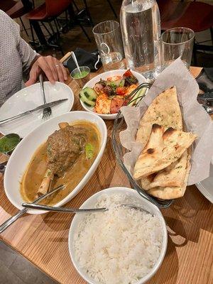 Lamb Shank Nihari, Paneer Tikka, and Garlic Naan on top of bread basket