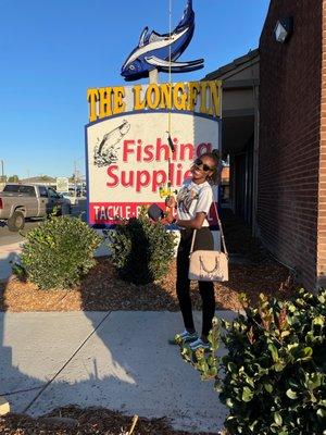 Yellow fishing rod, hat, smiles, sign